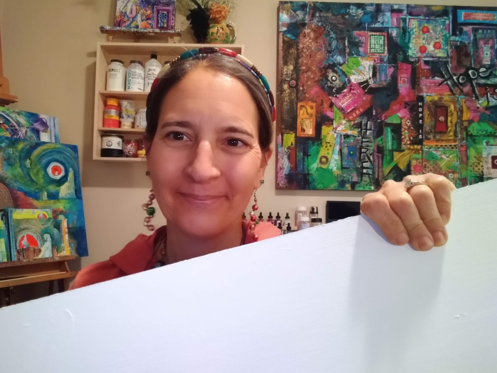 This photograph is of an experimental artist holding a blank canvas.