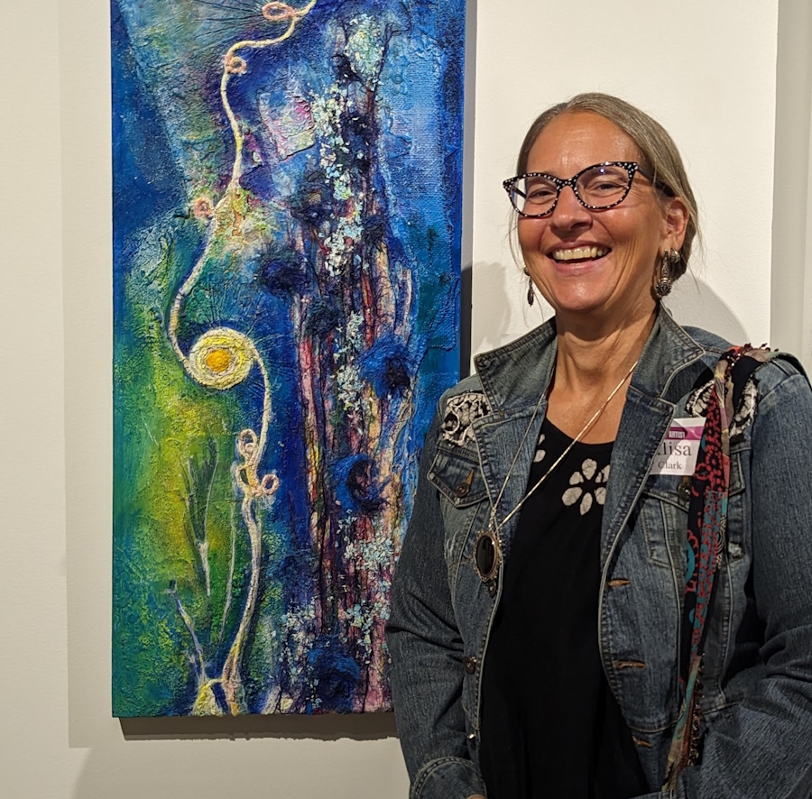 Artist, Alisa E. Clark, with her collage titled “Beneath It All” at the “94th Michigan Contemporary Art Exhibit.”