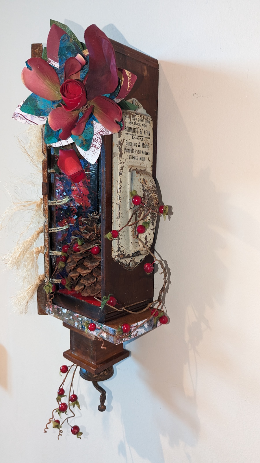 This is a 3D assemblage sculpture made from a small box that's filled with monoprint flowers, a pinecone, and vintage items.
