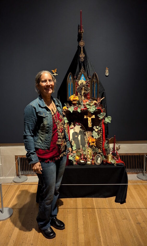 An intricate ofrenda combining family memorabilia, Greek iconostases, and Day of the Dead elements. Adorned with marigolds, candles, and photographs, it features 'Ottillie’s Basket' alongside tokens like prayer beads, grapes, and bread, celebrating remembrance and ancestral connections.